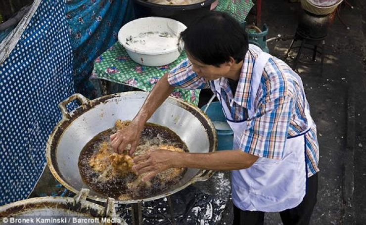 Tailandês coloca suas mãos no óleo fervendo sem queimar-se