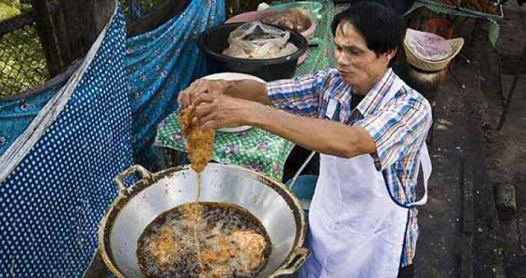 Tailandês coloca suas mãos no óleo fervendo sem queimar-se