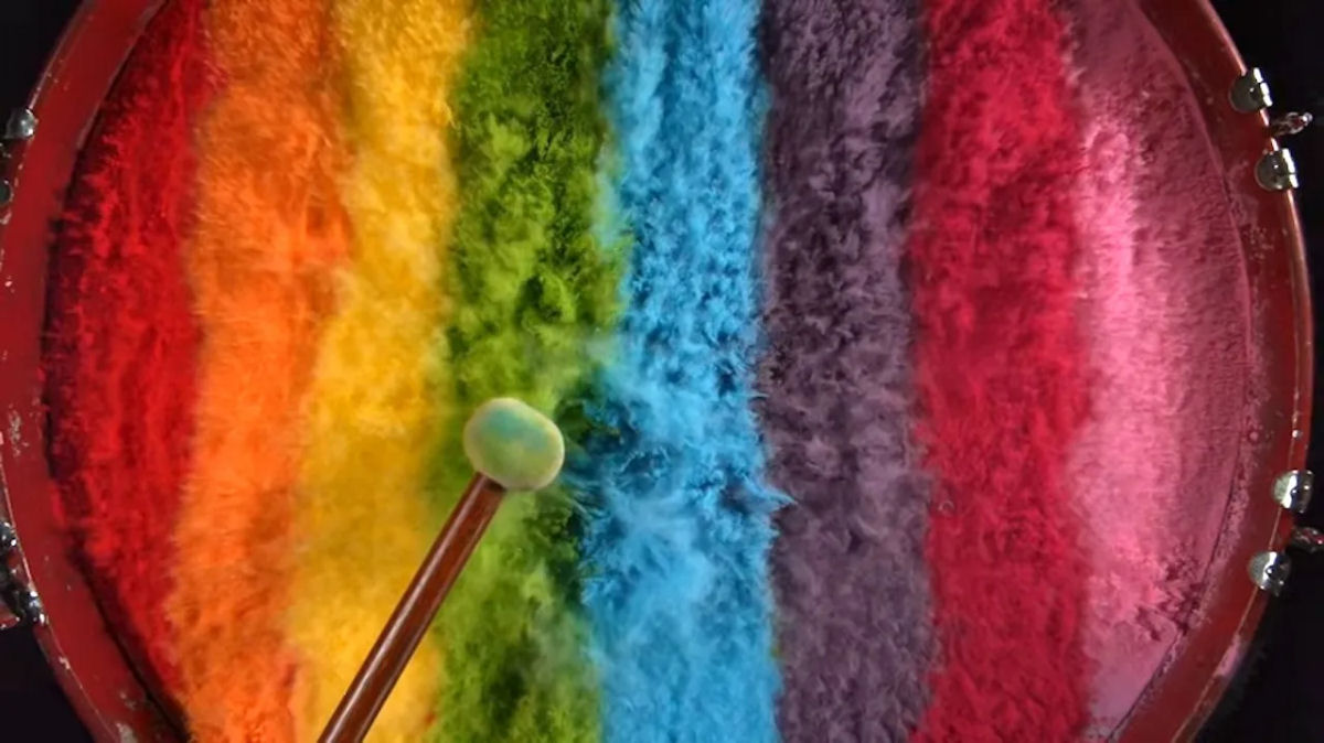 Pós coloridos vibrantes explodem de um tambor em câmera lenta