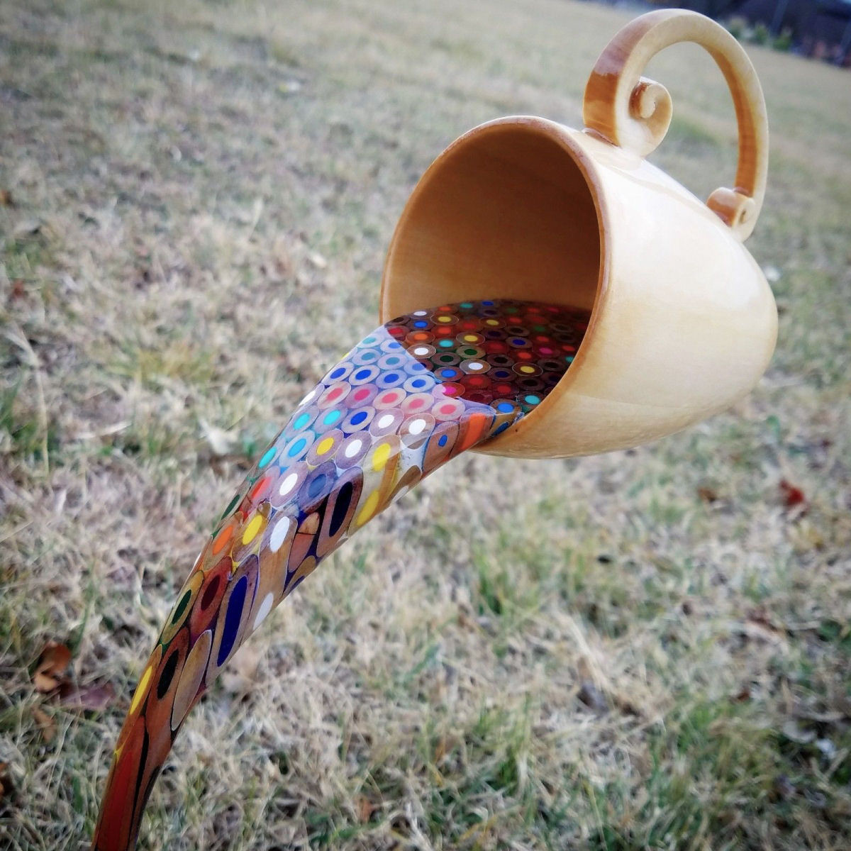 Bela obra mostra uma xícara flutuante vertendo um arco-íris de lápis líquidos 01