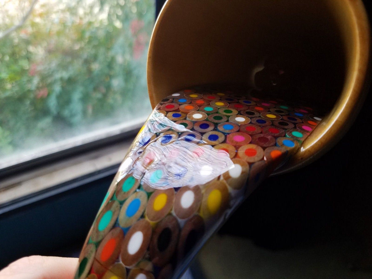 Bela obra mostra uma xícara flutuante vertendo um arco-íris de lápis líquidos 02