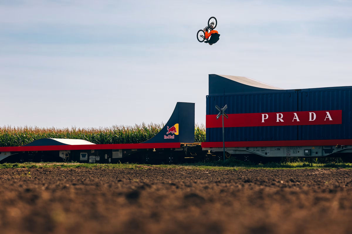 Ciclista Freestyle realiza manobras pedalando em cima de um trem em movimento