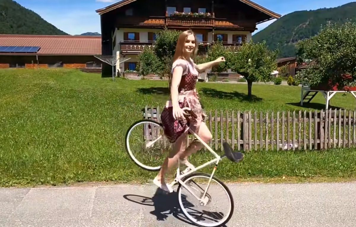 Bela alemã faz belos truques de bike tendo a bela paisagem austríaca como fundo