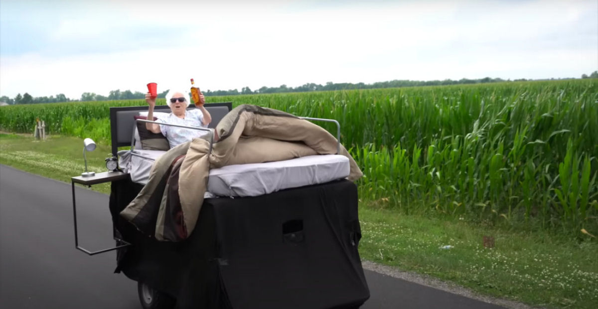 Vov anda em uma cama motorizada gigante pela cidade