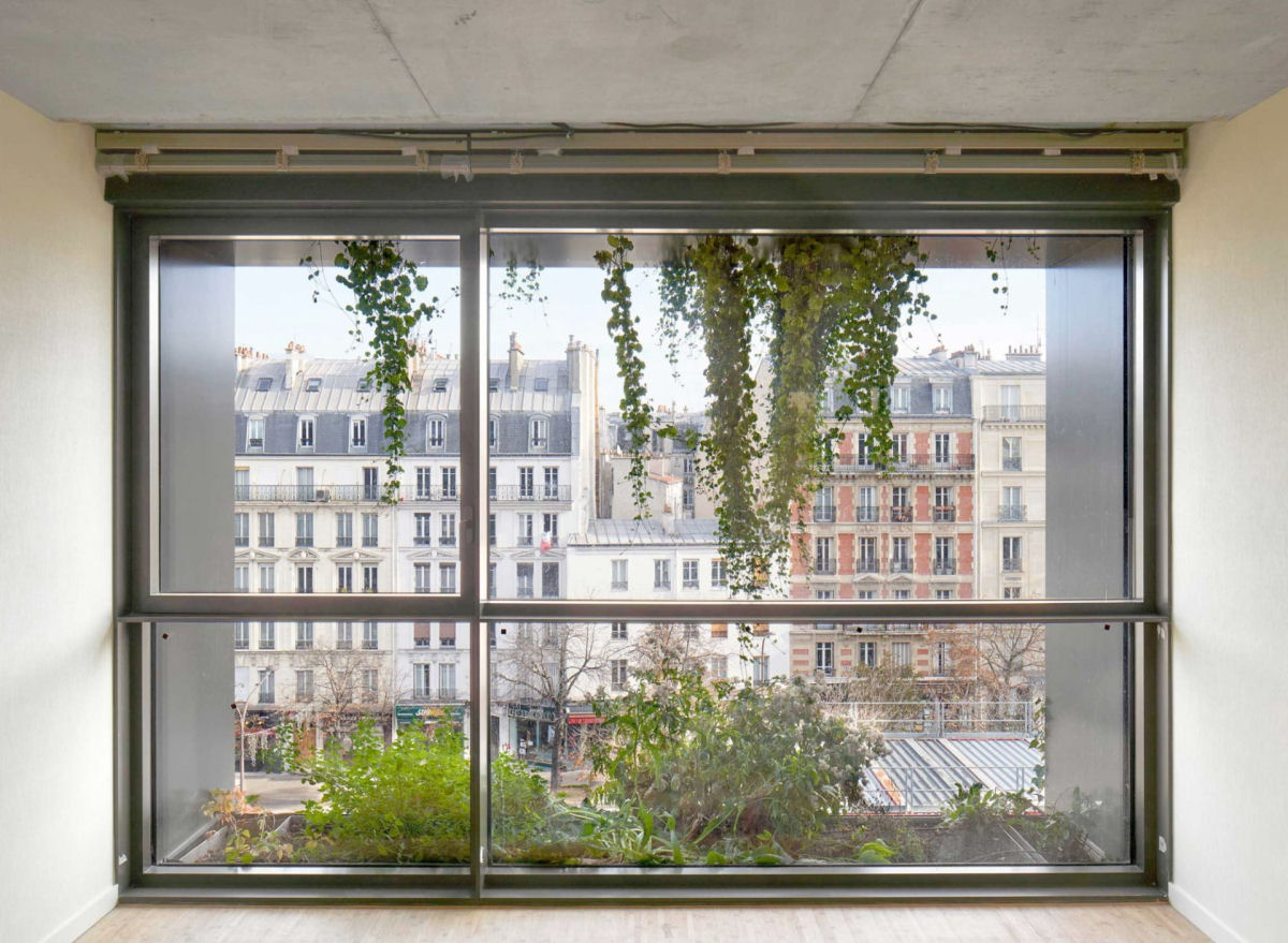 Um jardim vertical luxuriante brota de uma fachada minimalista repleta de janelas em Paris 06