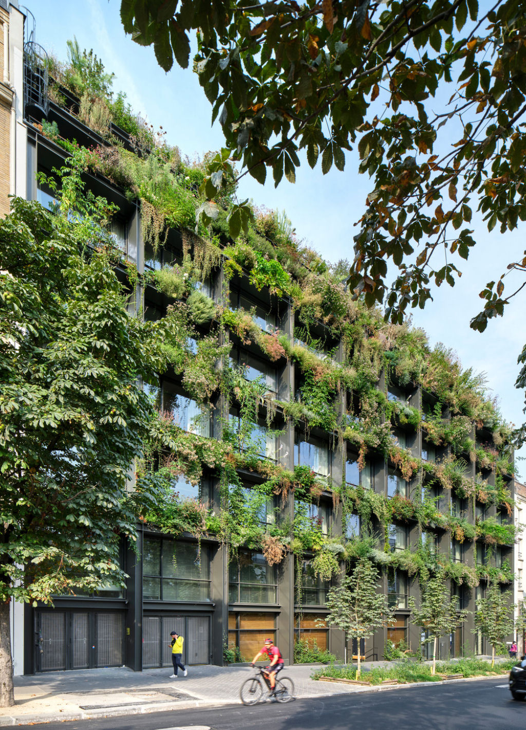 Um jardim vertical luxuriante brota de uma fachada minimalista repleta de janelas em Paris 08