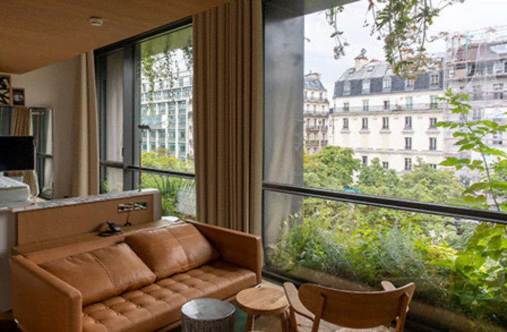 Um jardim vertical luxuriante brota de uma fachada minimalista repleta de janelas em Paris 13