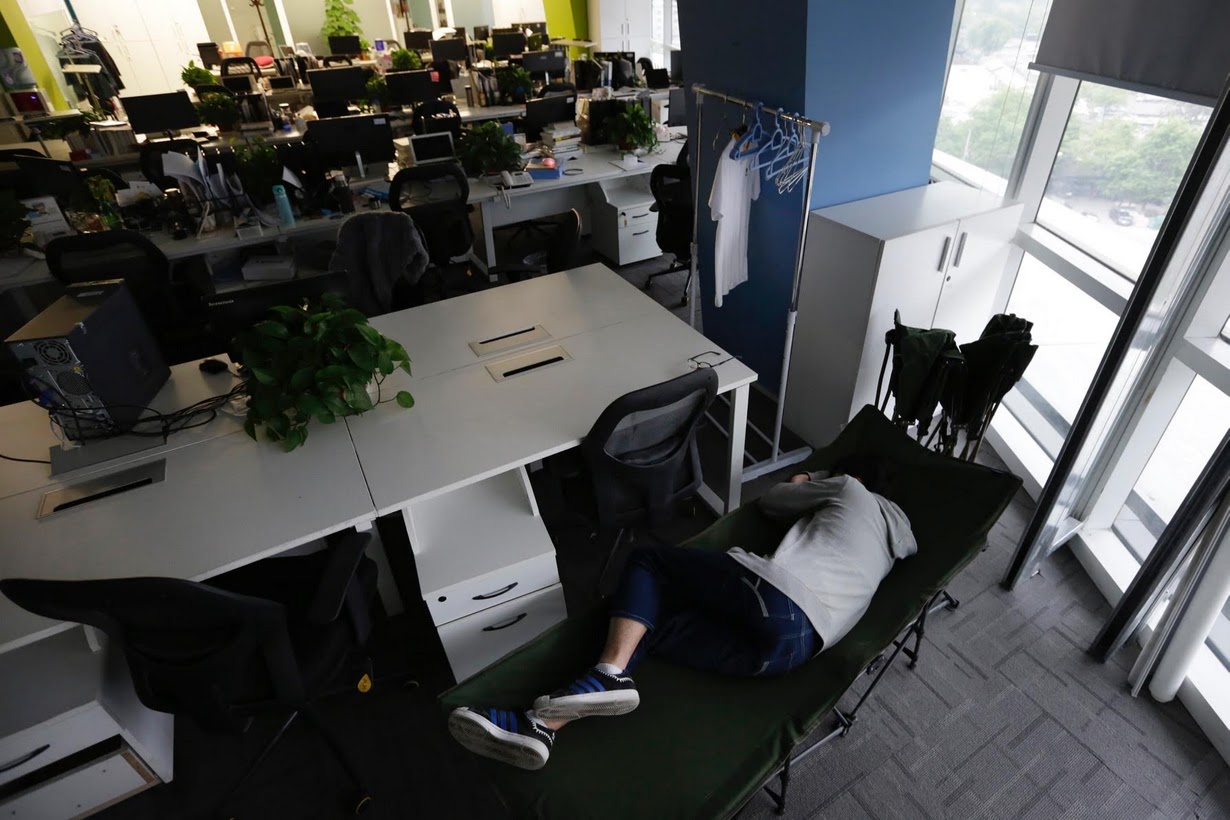 Os viciados em trabalho chineses comem e dormem em seus escritórios 11