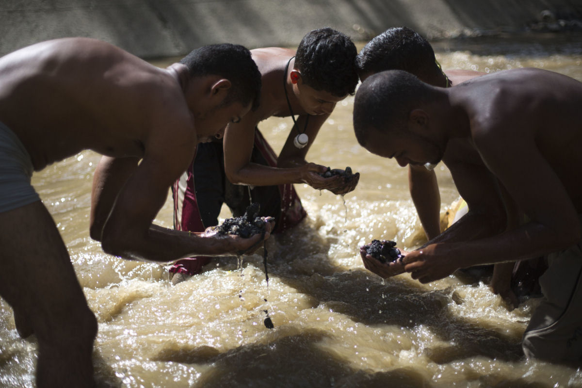 O drama dos jovens venezuelanos que garimpam sucata em um rio poludo para revend-la e poder comer 01