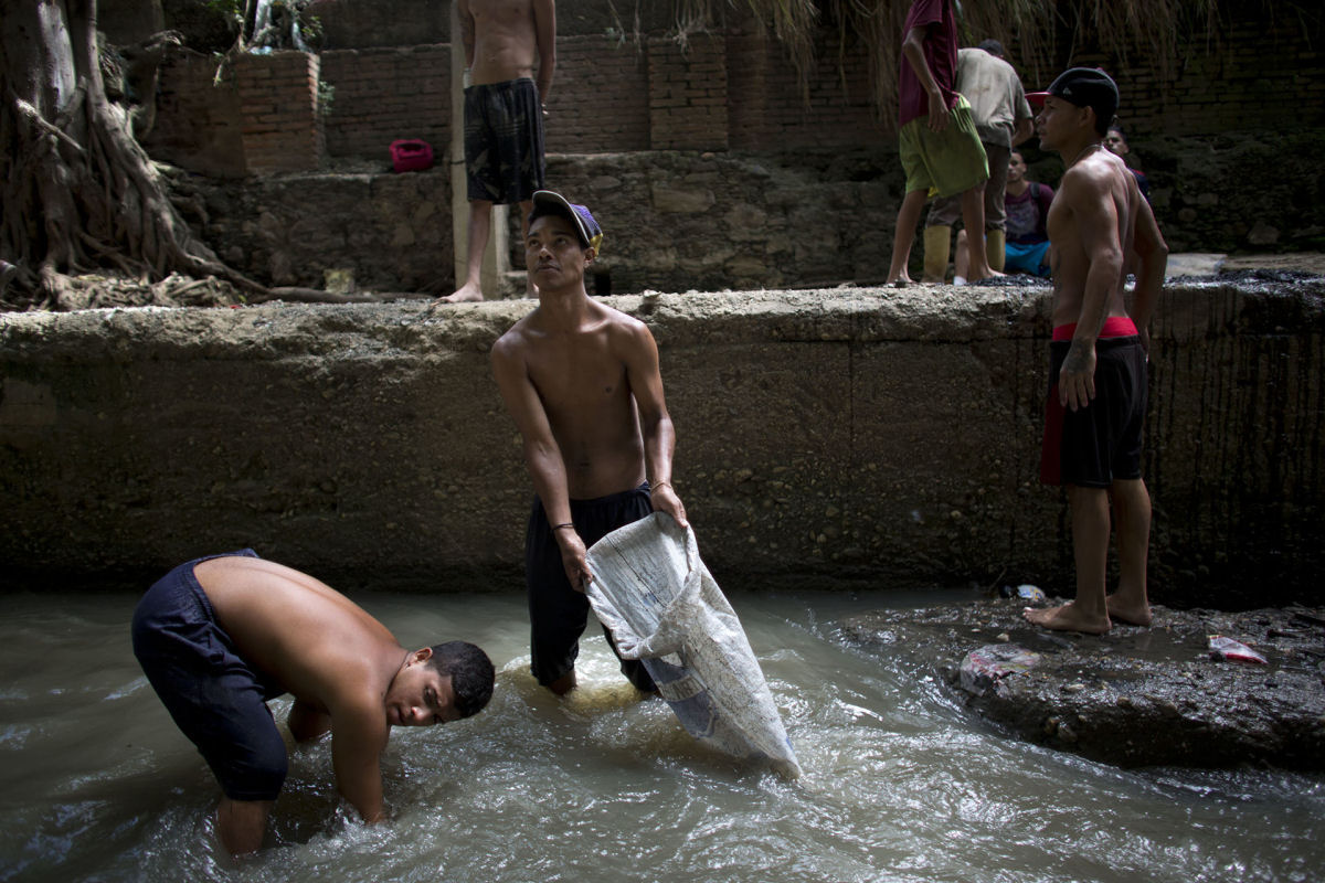 O drama dos jovens venezuelanos que garimpam sucata em um rio poludo para revend-la e poder comer 02