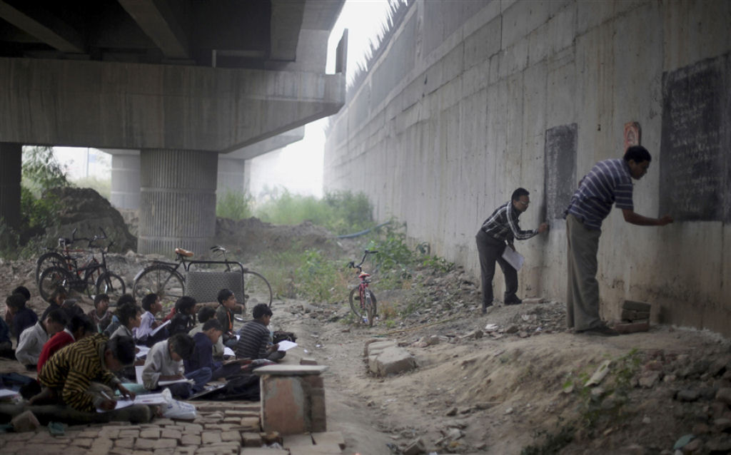 Crianças carentes indianas frequentam a escola ao ar livre debaixo de uma ponte 01