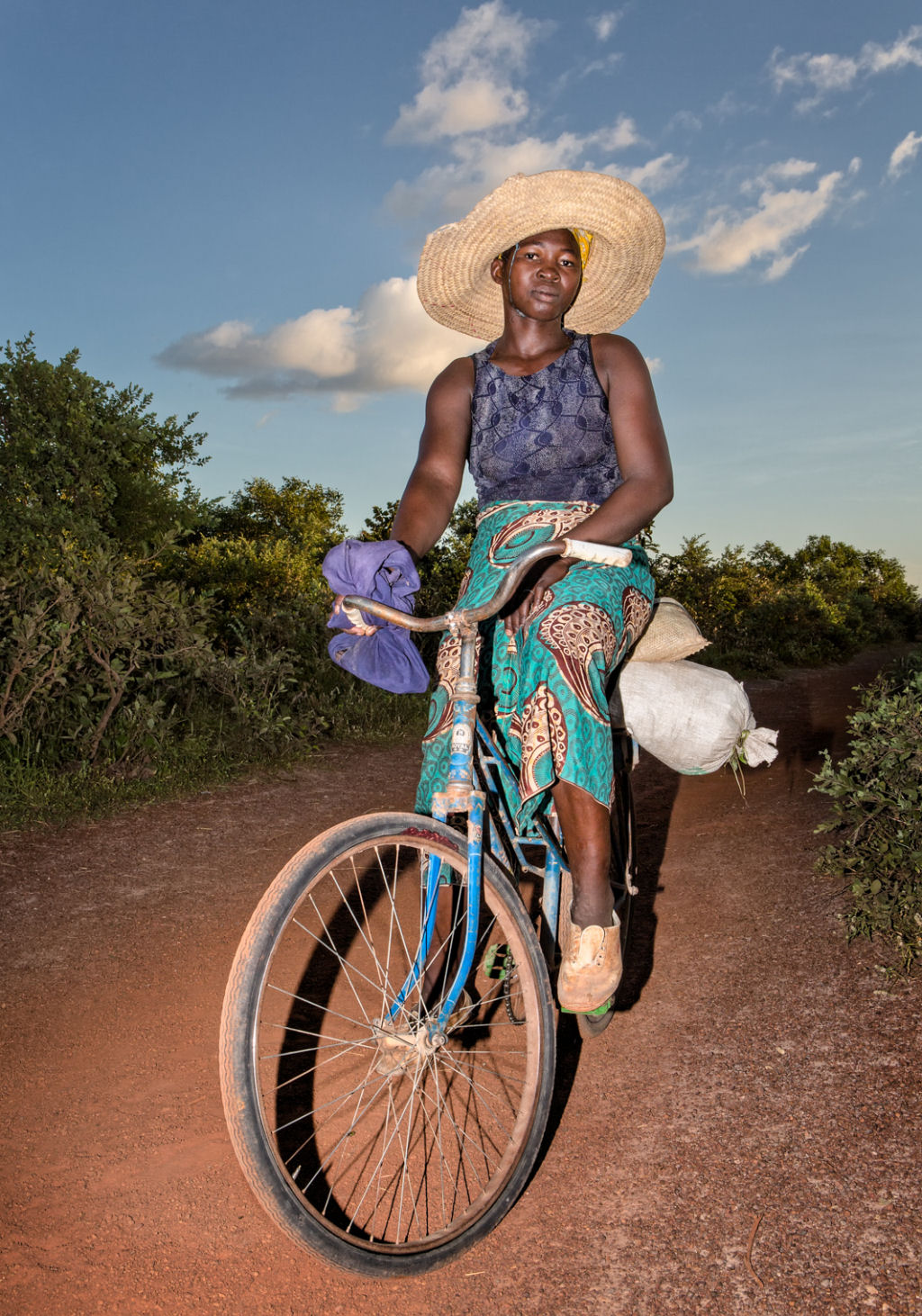 As pessoas que cruzam uma estradinha de uma vila rural africana 02