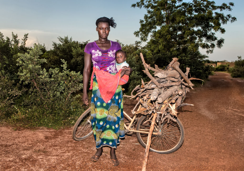 As pessoas que cruzam uma estradinha de uma vila rural africana 06