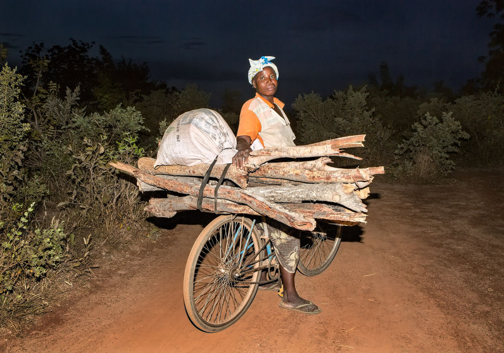 As pessoas que cruzam uma estradinha de uma vila rural africana 11