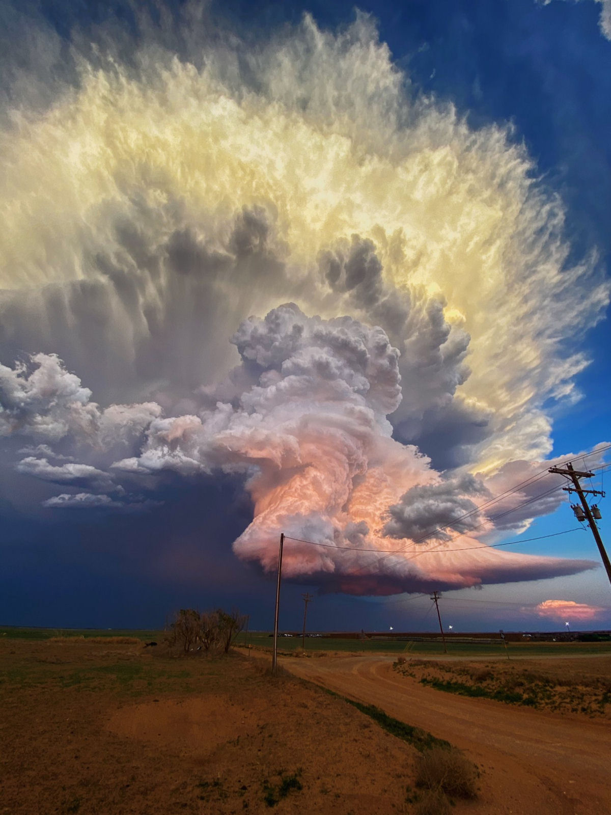 Nuvem cor de algodão-doce paira sobre uma paisagem em meio a uma tempestade