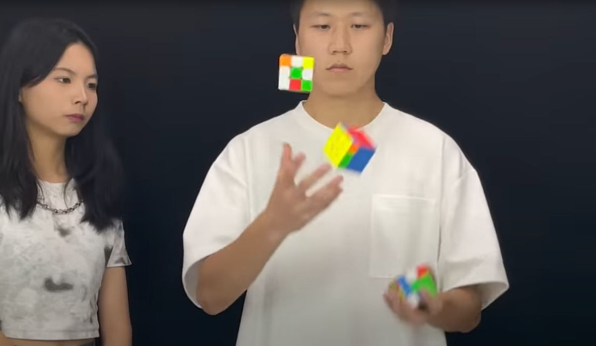 Jovem chins resolve trs cubos de Rubik em apenas trs minutos e meio fazendo malabarismos com eles