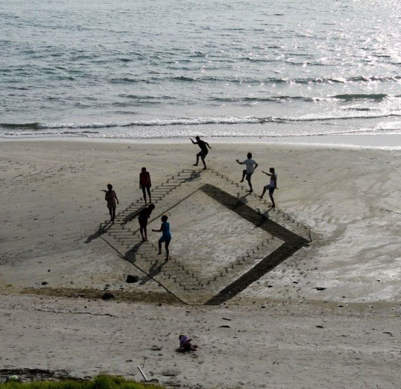 Artista usa um pedao de pau para criar criativos desenhos tridimensionais na praia 06