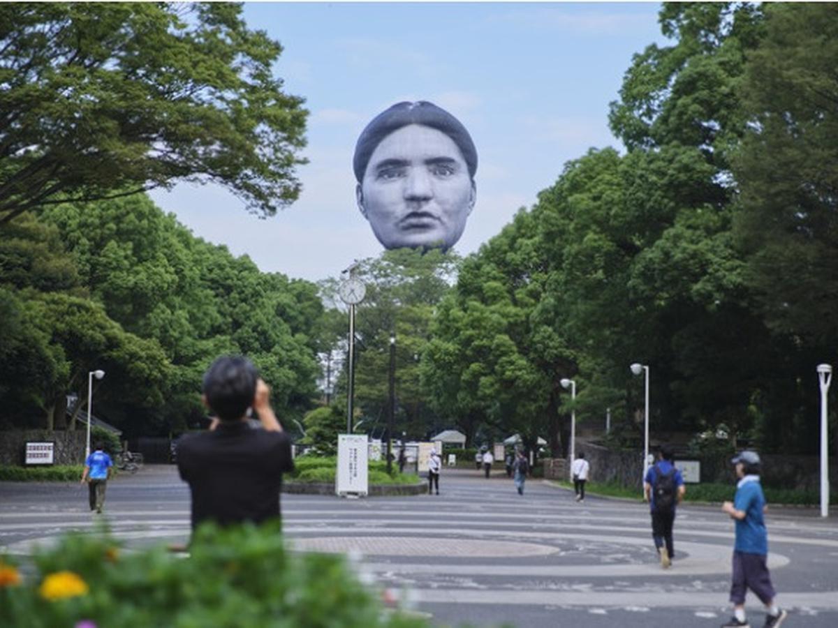 Uma cabeça gigante flutuante aparece no céu acima do centro de Tóquio