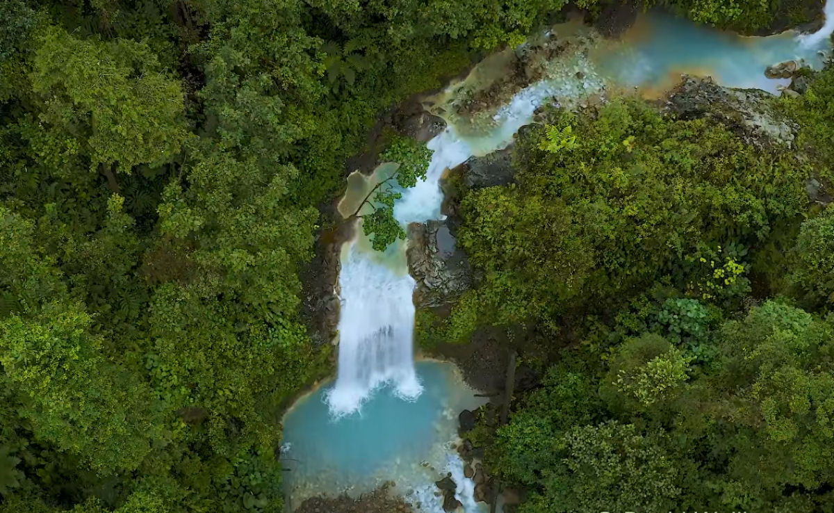 Belas imagens aéreas de uma cachoeira azul turquesa na floresta tropical da Costa Rica