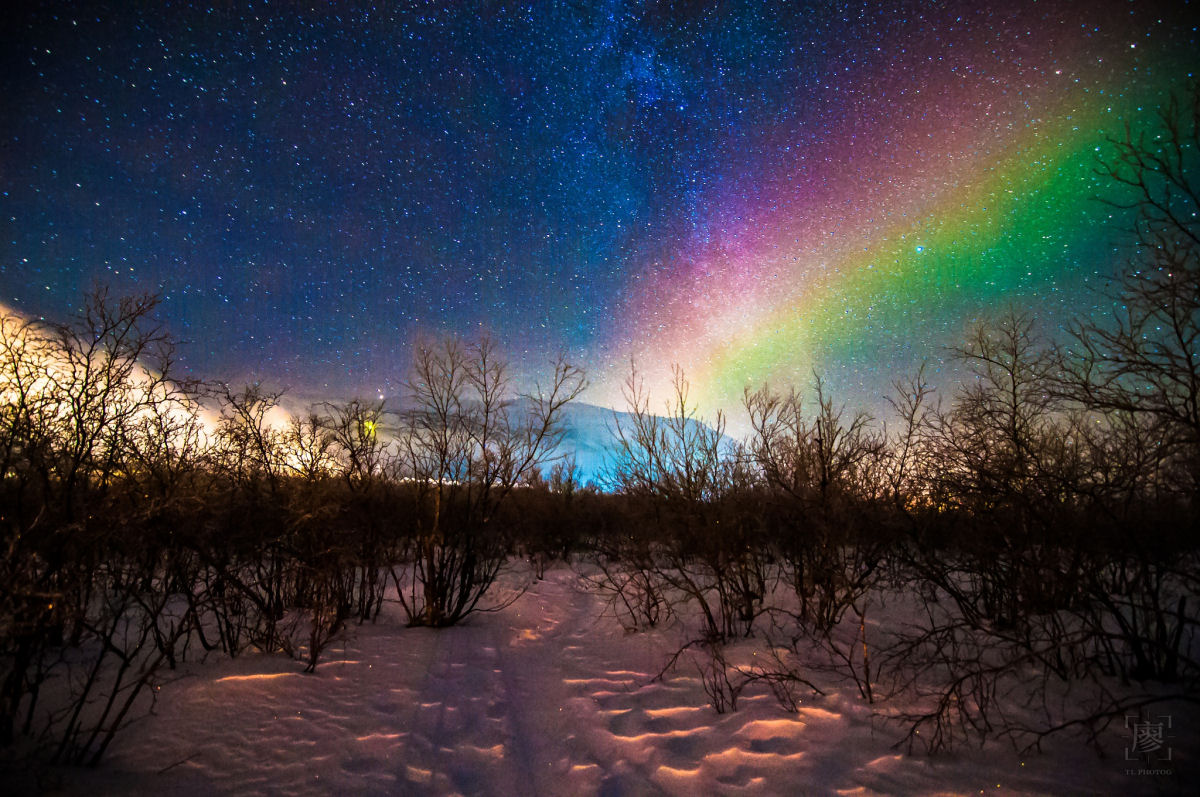 Arco-iris sobre as Luzes do Norte espelhada na Via Lctea.