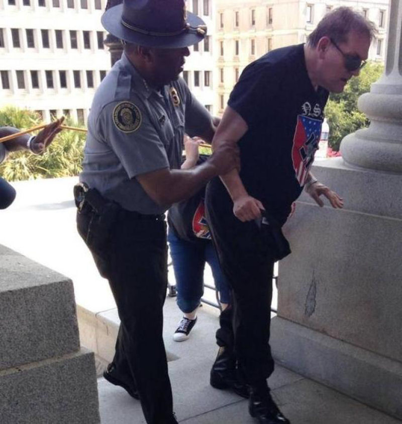 Um policial negro ajudando um membro da KKK sofrendo de insolao.