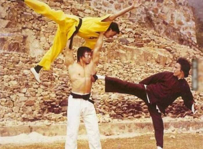 Bolo Yeung usando Jackie Chan como arma contra Bruce Lee.