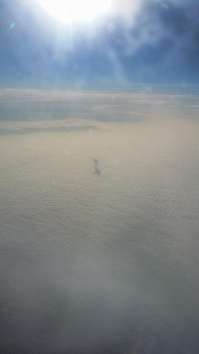 Um homem sobre as nuvens. (visto da janela de um avião)