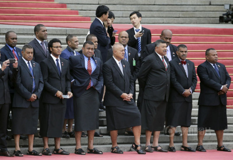 Membros do governo de Fiji vestindo saias tradicionais em visita oficial a China.