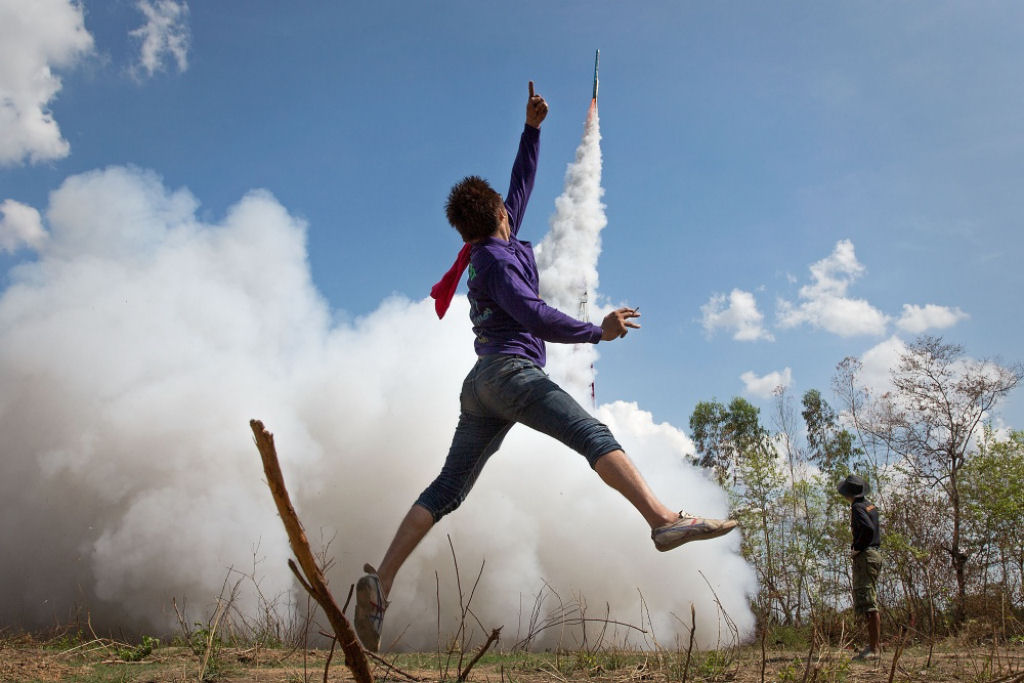 Uhull! Jovem salta de alegria no festival de foguetes de Bung Bang Fai para celebrar a esperada temporada de chuvas. Yasothon, Tailândia. Por Taylor Weidman.