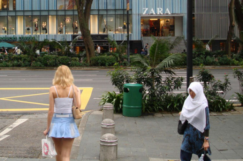 Duas mulheres caminham pela rua durante sua jornada quotidiana.