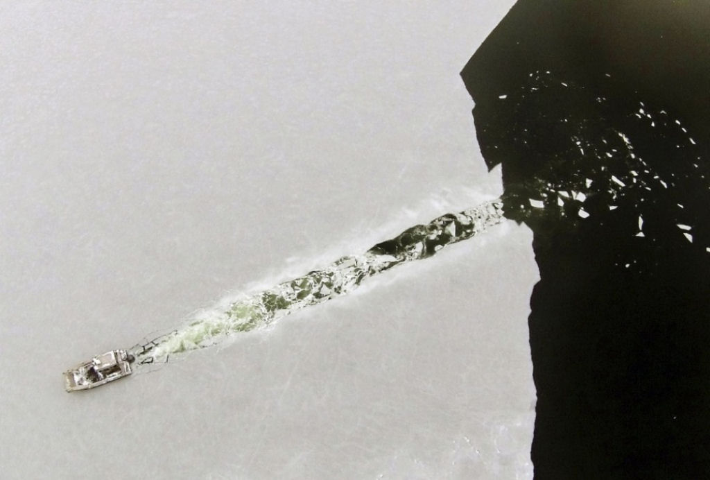 Um barco atravessa uma camada de gelo recm formado. Por Peter Pereira.