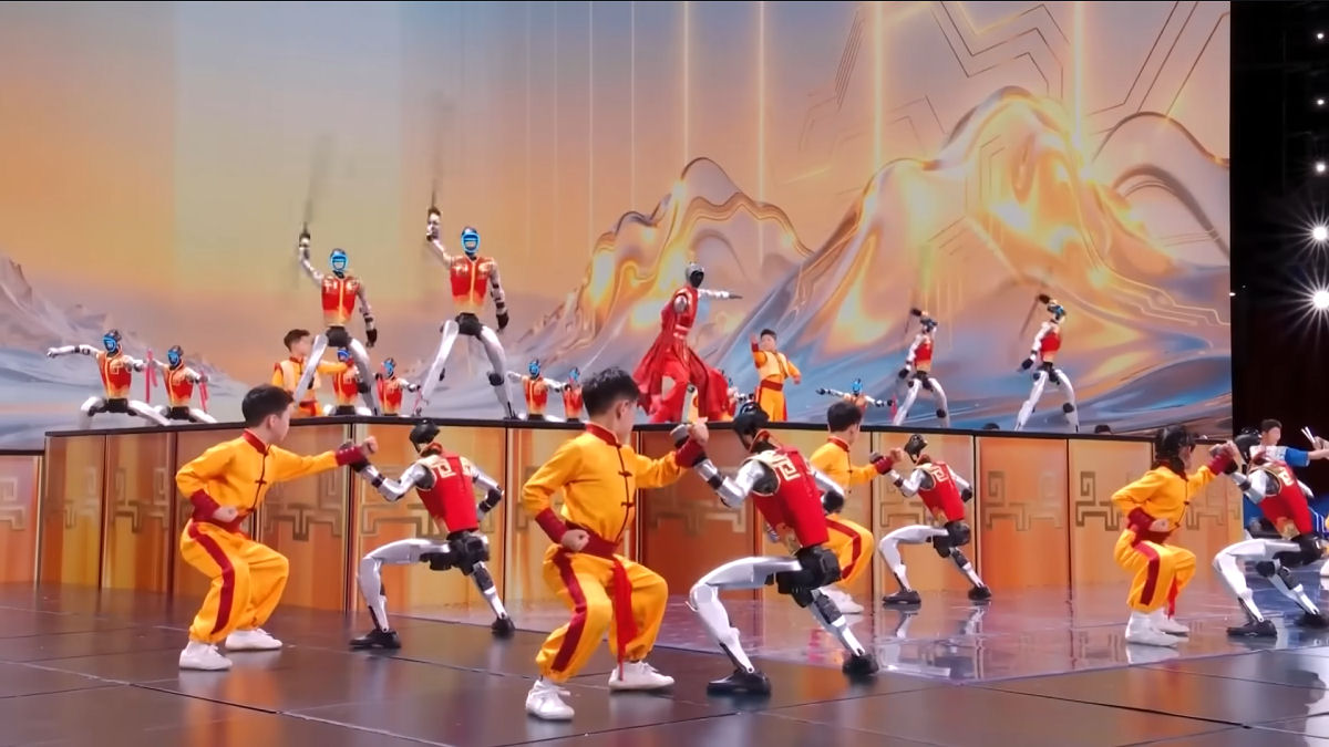 Jovens artistas marciais dan�am em perfeita sincronia com rob�s humanoides