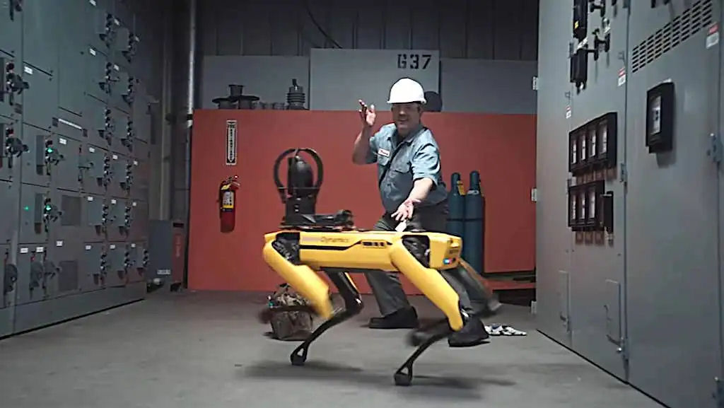 Funcionário de armazém faz o seu melhor para fazer o robocão Spot dançar com ele