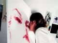 Artista pinta quadro com os lábios