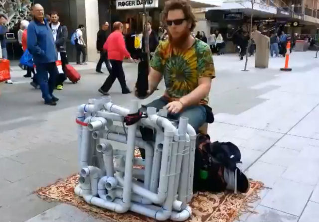 Épica performance de músico de rua com intrumento feito de canos