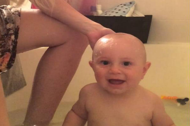 Bebê acha que mamãe despejando água sobre sua cabeça é a coisa mais engraçada do mundo