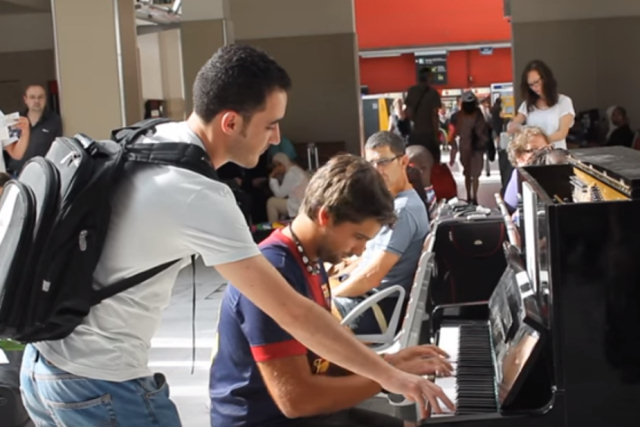 Dois estranhos tocam piano em perfeita sincronia em uma estação ferroviária de Paris