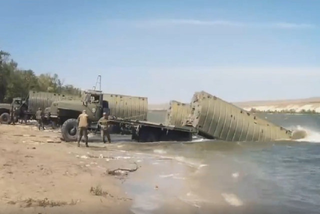 A extrema coordenação de soldados russos construindo uma grande ponte flutuante