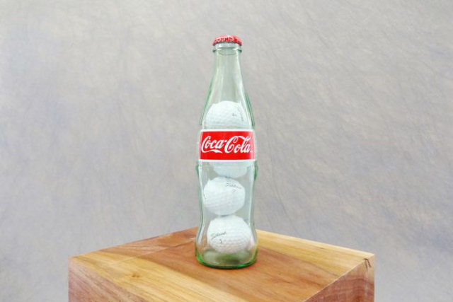 Como colocar quatro bolinhas de golfe em uma garrafa de Coca-Cola