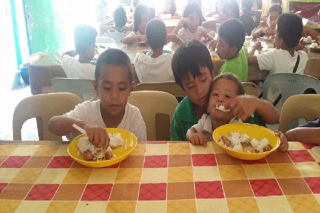 Menino filipino determinado a terminar os estudos leva seu irmão menor para a escola