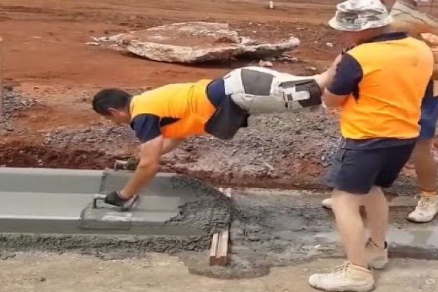 Trabalhadores da construção brincam de carrinho de mão para fazer seu trabalho