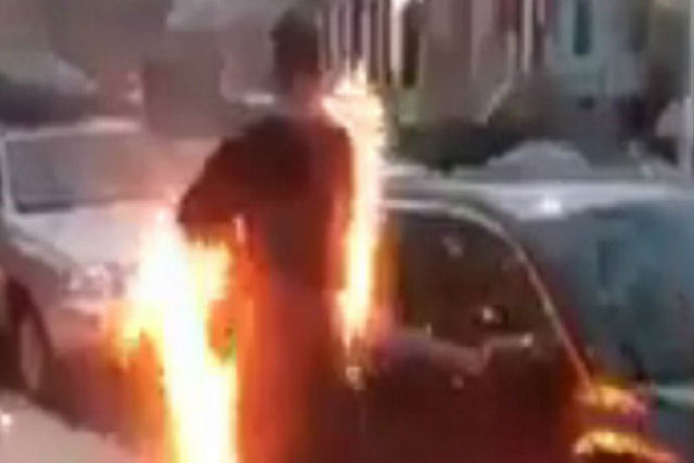 Um nova-iorquino engolfado nas chamas andando calmamente pela calçada