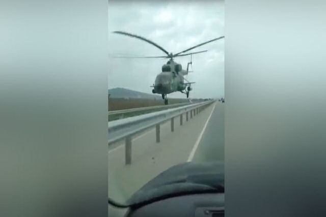 Um helicóptero voa a poucos metros sobre rodovia na Chechênia