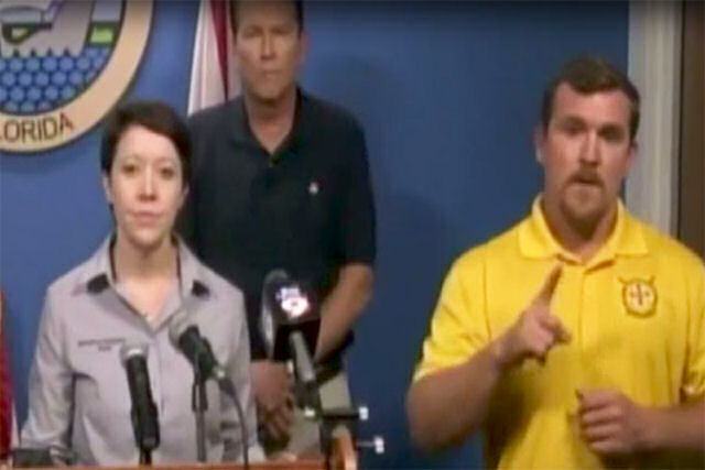 Um intérprete de surdos fala de ursos e monstros durante uma conferência de imprensa sobre Irma