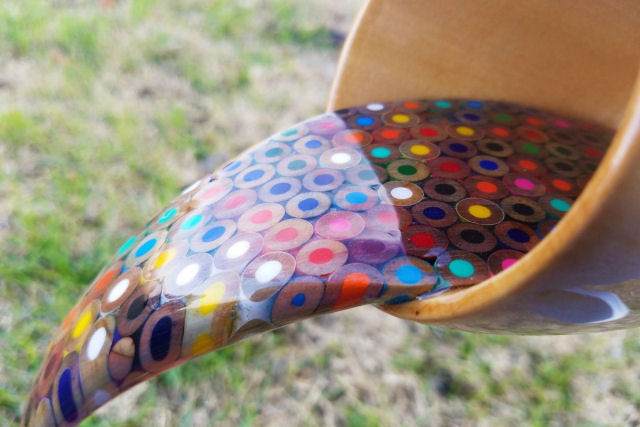Bela obra mostra uma xícara flutuante vertendo um arco-íris de lápis líquidos