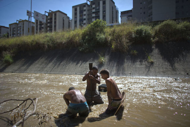 O drama dos jovens venezuelanos que «garimpam» sucata em um rio poluído para revendê-la e poder comer