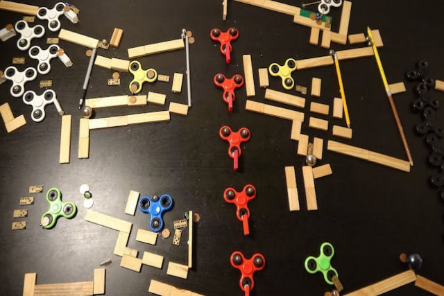 Um labirinto elaborado de Rube Goldberg que conecta o movimento de fidgets com bolinhas de gude