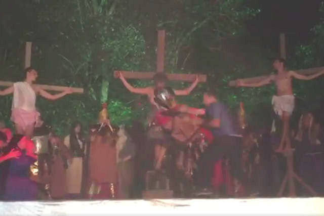 Homem tenta salvar Jesus da cruz durante encenao da Paixo de Cristo