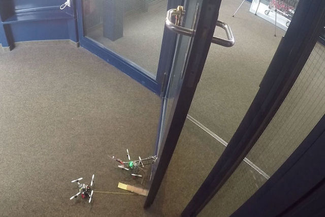 Pequenos drones trabalham em conjunto para abrir uma porta pesada