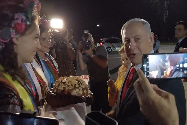 Na sua chegada  Ucrnia, mulher de Netanyahu joga no cho o tradicional po que simboliza a hospitalidade